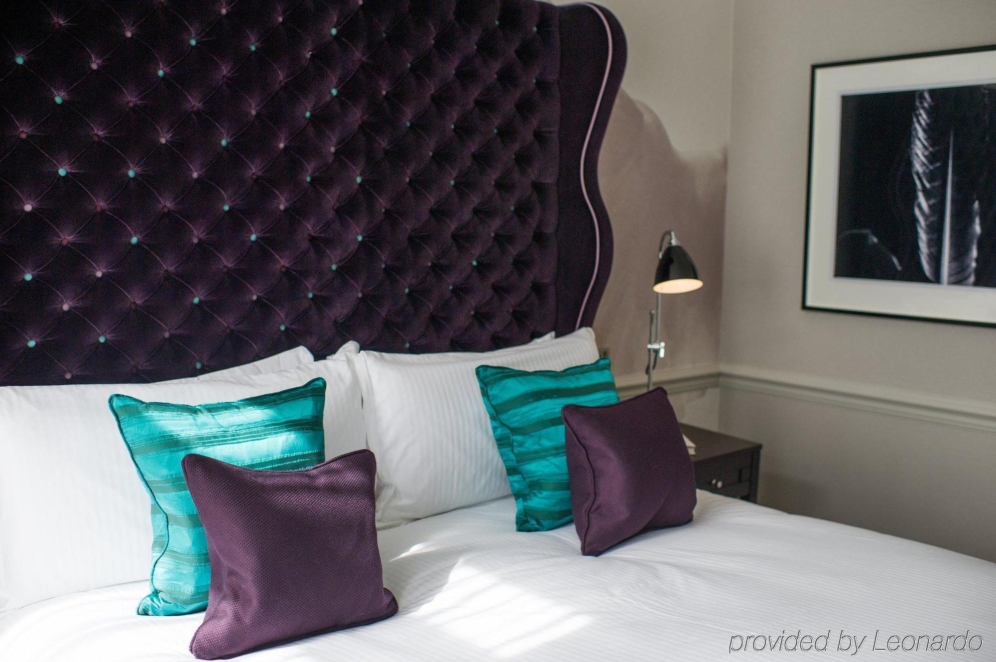 โรงแรมดิแอมเพอร์ซานด์ ลอนดอน ห้อง รูปภาพ A bed with cushions